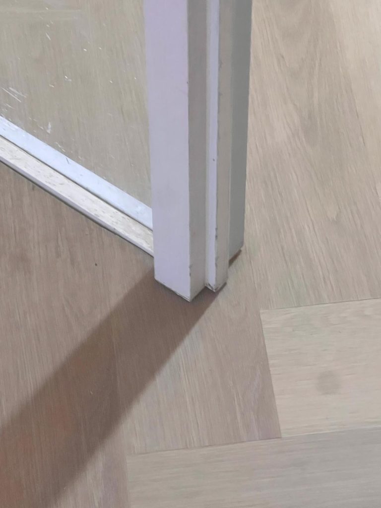 Detail van de vloerafwerking rondom een deurkozijn