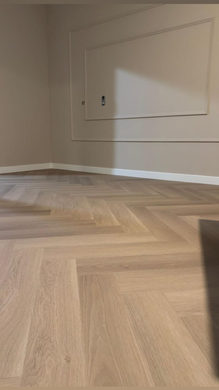 Detail van een visgraatvloer langs de wand
