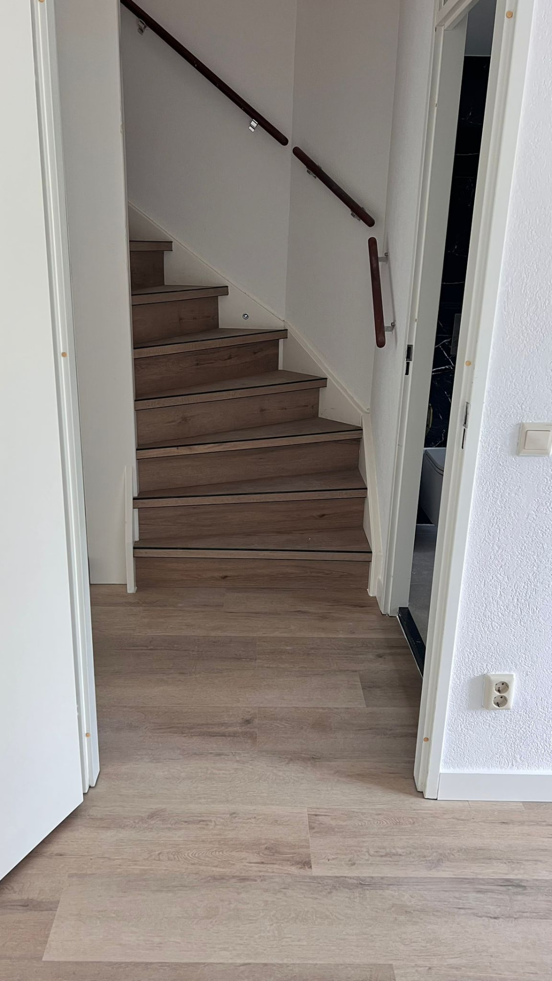 Trap in lichte houtlook-visgraat in een gang